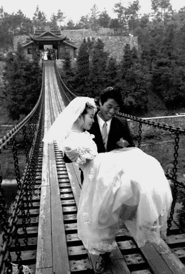 Жених и невеста на цепном мосту в Мемориальном парке Мао Цзэдуна в провинции Хунань - Sputnik Казахстан