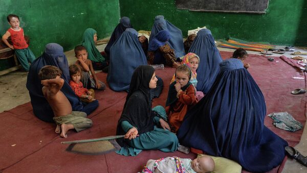 Женщины и дети сидят на полу в лагере для беженцев в провинции Кунар - Sputnik Қазақстан