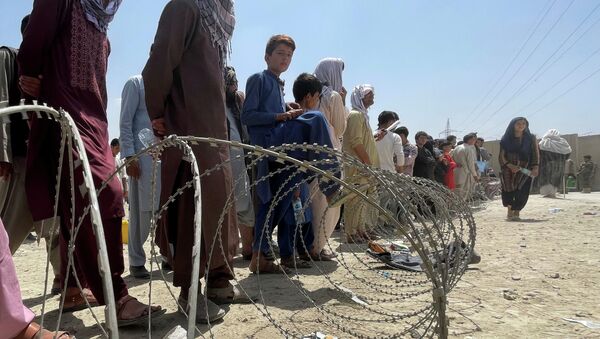 Люди стоят у ограждений из колючей проволоки близ аэропорта Кабула - Sputnik Казахстан