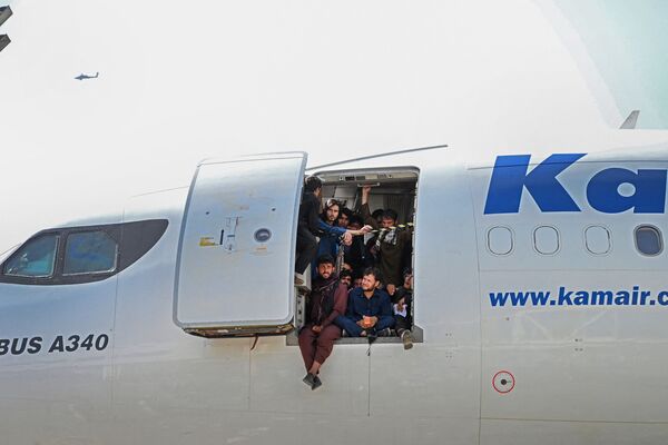 Афганцы сидят в дверях самолета в аэропорту Кабула  - Sputnik Казахстан