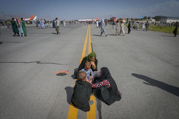 Афганцы на взлетной полосе в аэропорту Кабула  - Sputnik Казахстан
