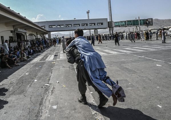 Волонтер с раненым афганцем в аэропорту Кабула  - Sputnik Казахстан