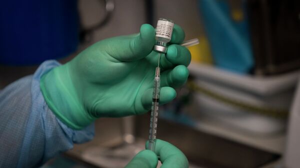 Медик в защитном костюме готовит шприц с вакциной от коронавируса  - Sputnik Казахстан