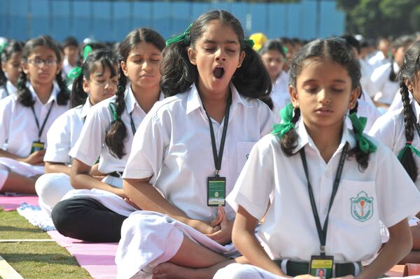 Индийская девочка зевает во время занятия йогой в школе.  - Sputnik Казахстан
