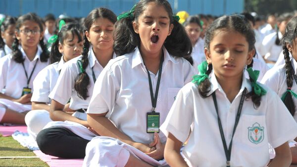 Индийская девочка зевает во время занятия йогой в школе.  - Sputnik Қазақстан