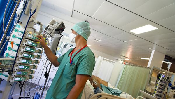 Медик следит за аппаратурой в отделении реанимации в больнице с коронавирусом - Sputnik Казахстан