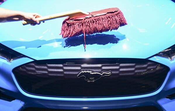 Рабочий чистит капот электромобиля Ford Mustang Mach-E GT на стенде Ford на открытии Международного Мюнхенского автосалона в Германии - Sputnik Казахстан