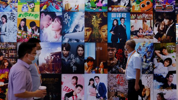 Люди проходят мимо афиши китайских фильмов и телепрограмм на Китайской международной ярмарке торговли услугами (CIFTIS) 2021 года в Пекине - Sputnik Казахстан