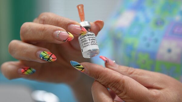 Медсестра держит пузырек с вакциной от коронавируса  - Sputnik Қазақстан