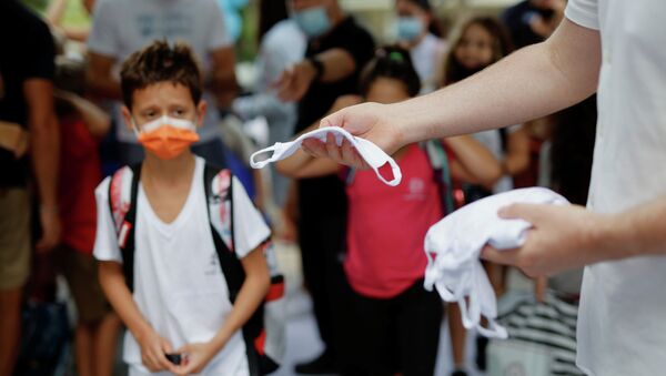 Сотрудник школы раздает маски ученикам на входе - Sputnik Казахстан