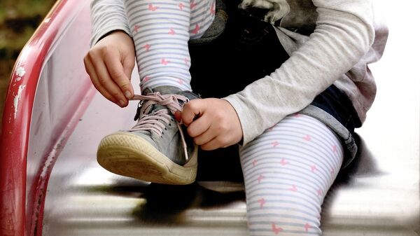 Девочка завязывает шнурки на ботинках - Sputnik Казахстан