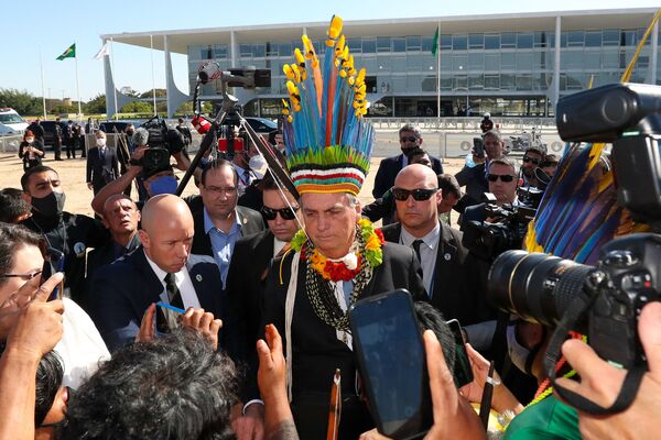  Президент Бразилии Жаир Болсонару в головном уборе коренного населения в Бразилиа - Sputnik Казахстан