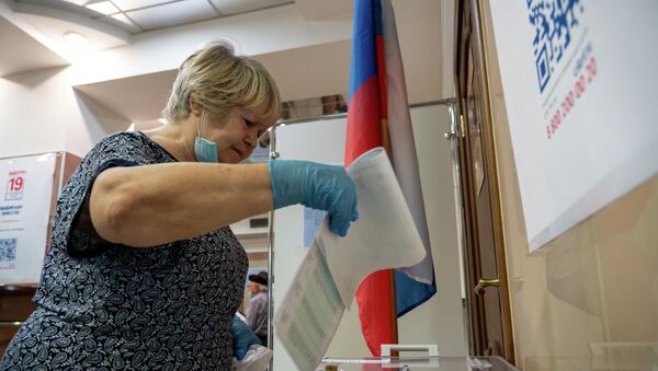 Избирательница опускает бюллетень в урну для голосования на выборах в Госдуму России - Sputnik Казахстан
