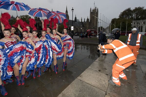 Рабочие фотографируют танцовщиц из парижского кабаре Мулен Руж в Лондоне  - Sputnik Қазақстан