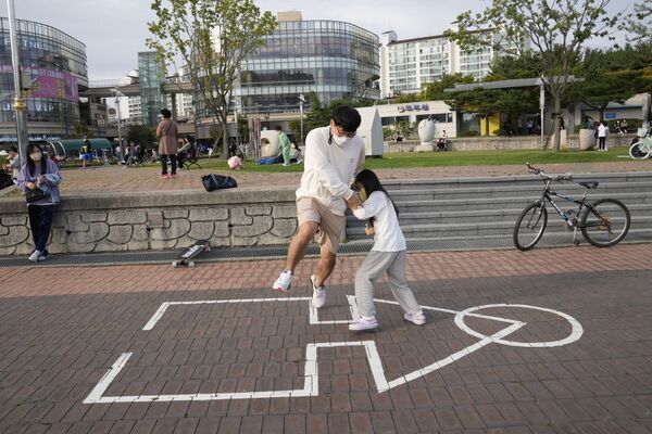 Сон Кван Чже и его дочь Чжэ Ин играют в оригинальную «Игру в кальмара» в парке в Кояне, Южная Корея - Sputnik Қазақстан