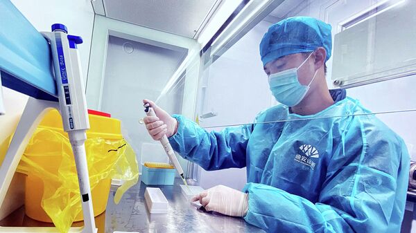 Сотрудник лаборатории исследует образцы ПЦР-тестов на коронавирус - Sputnik Казахстан