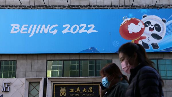Люди напротив баннера Олимпийских игр в Пекине в Китае  - Sputnik Қазақстан