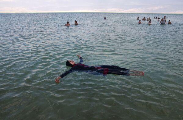 Люди купаются на израильском курорте Неве Зоар в южной части Мертвого моря - Sputnik Казахстан