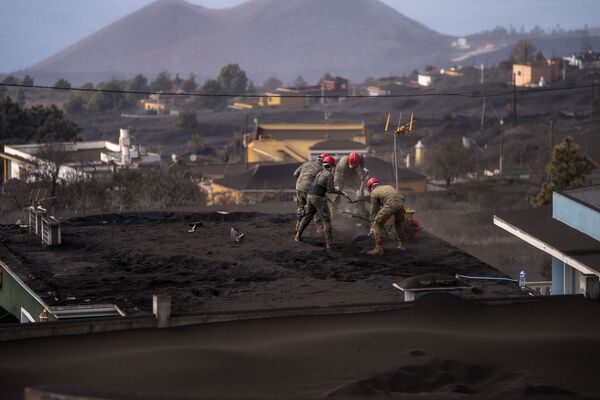 Армия очищает крышу дома от пепла вследствие извержения вулкана на острове Пальма - Sputnik Казахстан