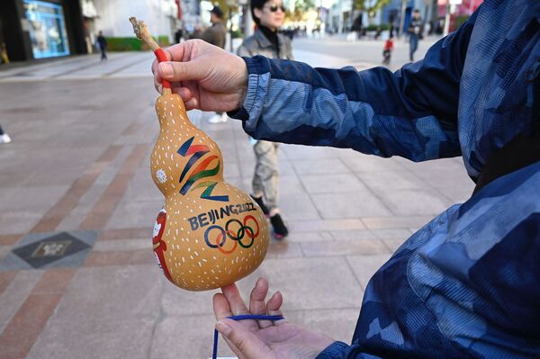 Мужчина показывает тыкву с изображением логотипа Зимних Олимпийских игр в Пекине  - Sputnik Казахстан