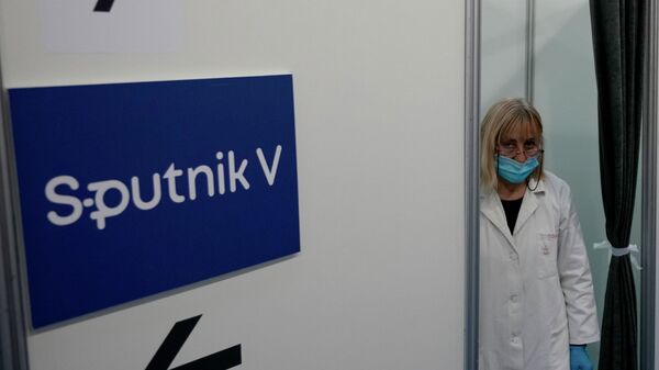 Врач стоит у кабинки с указателем вакцины Спутник V - Sputnik Казахстан