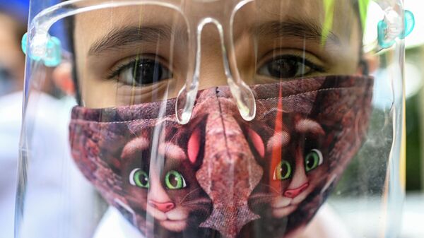 Ребенок в маске и защитном лицевом экране  - Sputnik Казахстан