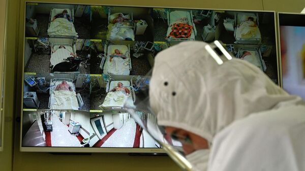 Медик в защитном костюме на дежурстве в отделении реанимации больницы с коронавирусом  - Sputnik Казахстан
