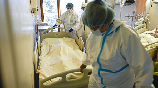 Медики в защитных костюмах вывозят из палаты реанимации тело скончавшегося от коронавируса пациента  - Sputnik Казахстан