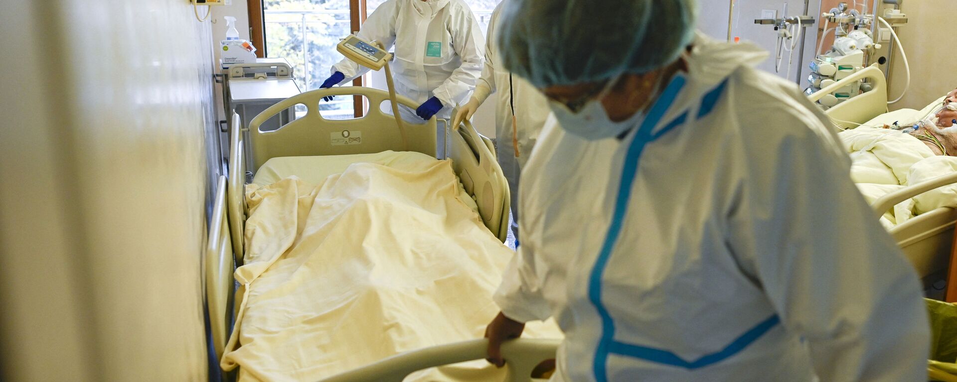 Медики в защитных костюмах вывозят из палаты реанимации тело скончавшегося от коронавируса пациента  - Sputnik Казахстан, 1920, 25.02.2022