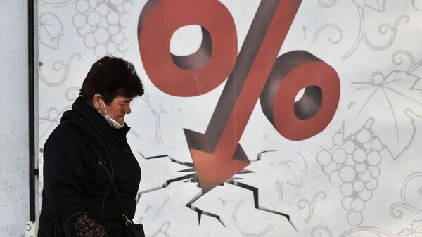 Женщина проходит мимо билборда со знаком процента  - Sputnik Казахстан