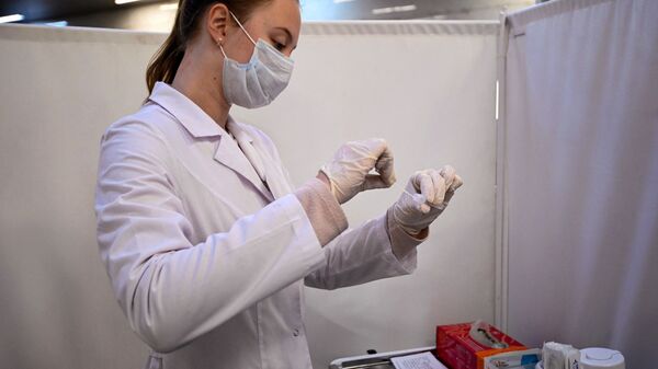 Медик в защитном костюме работает с набором для ПЦР-теста на коронавирус  - Sputnik Казахстан
