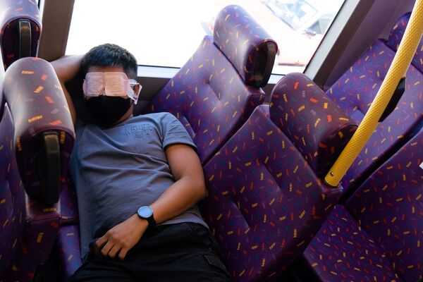 Пассажир спит в автобусе во время путешествия в никуда в Гонконге  - Sputnik Қазақстан