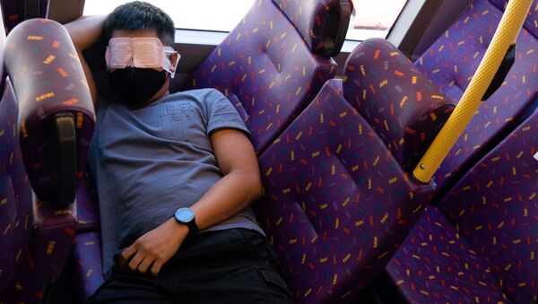 Пассажир спит в автобусе во время путешествия в никуда в Гонконге  - Sputnik Казахстан