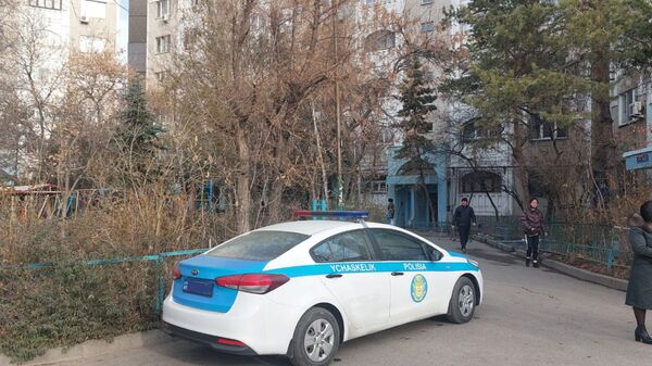 Полицейская машина у подъезда дома, в котором произошла трагедия с молодой матерью и детьми  - Sputnik Казахстан