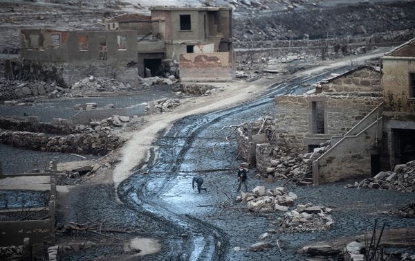 Люди прогуливаются среди руин испанской затопленной деревни Асередо  - Sputnik Казахстан