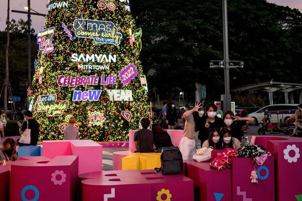 Молодежь собралась у рождественской елки в Бангкоке. Несмотря на то, что в этом городе не бывает белого рождества, главный атрибут праздника создает настроение.  - Sputnik Казахстан