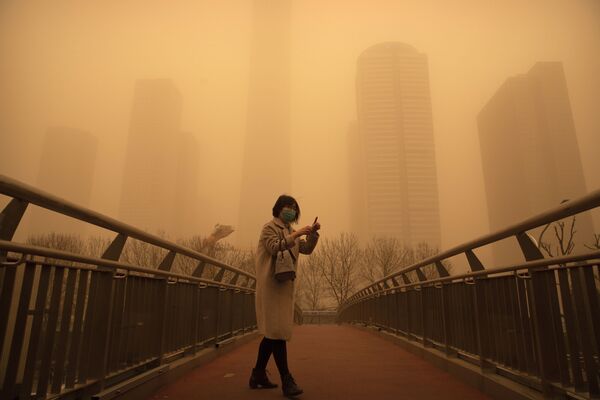 Женщина во время песчаной бури в Пекине. - Sputnik Казахстан