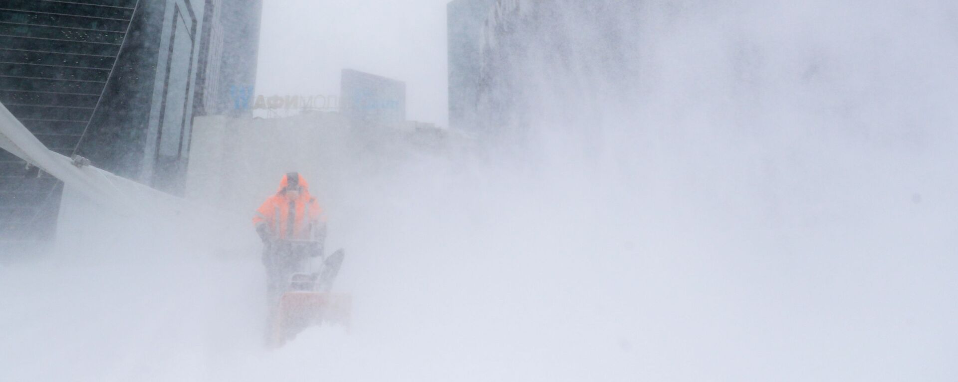 Сотрудник коммунальной службы убирает снег с площади у делового центра Москва-сити - Sputnik Казахстан, 1920, 29.03.2022