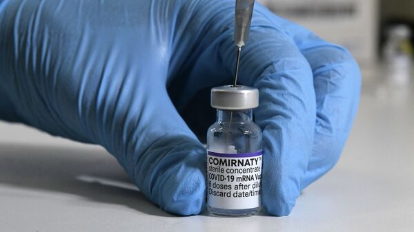 Медик держит в руках пузырек с вакциной от коронавируса  - Sputnik Казахстан