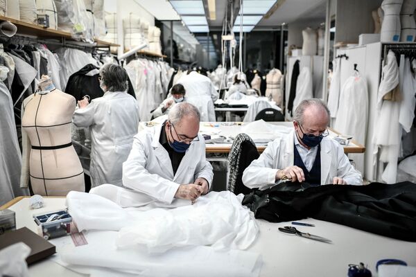 Жұмысшылар 2021 жылдың 20 ақпанында Париждегі Christian Dior сән үйінің шеберханасында кутюрье топтамасын тігіп отыр.  - Sputnik Қазақстан
