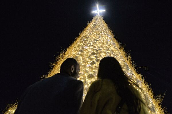 Люди у гигантской пушистой полой рождественской елки, установленной в преимущественно христианском городе Ирака Каракош (Багдеда), в провинции Ниневия, примерно в 30 километрах от Мосула.  - Sputnik Казахстан
