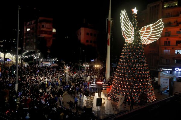 Люди у гигантской рождественской елки на площади Сассин в районе Ахрафие в Бейруте. - Sputnik Казахстан