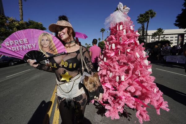 Сторонник Бритни фотографируется рядом с рождественской елкой Свободная Бритни, установленной фанатами перед зданием суда в Лос-Анджелесе.   - Sputnik Казахстан