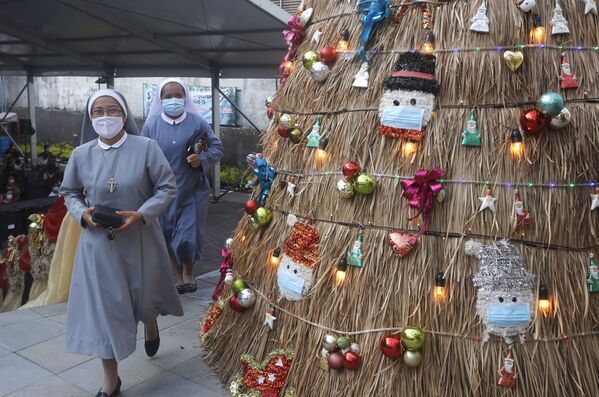 Монахини рядом с рождественской экоелкой с украшением на тему коронавируса в церкви на Бали.  - Sputnik Казахстан