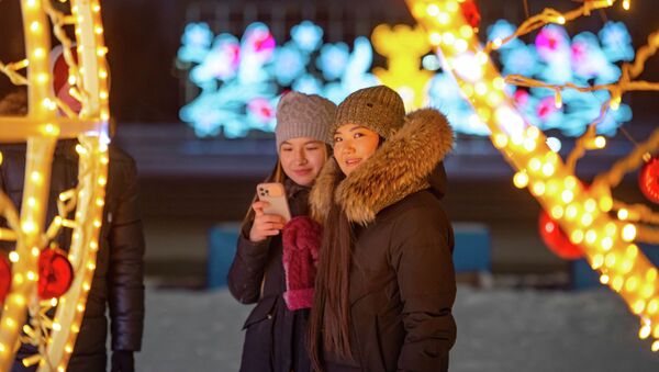 Астанчанки позируют на фоне новогодних украшений городских улиц - Sputnik Казахстан