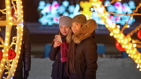 Астанчанки позируют на фоне новогодних украшений городских улиц - Sputnik Казахстан