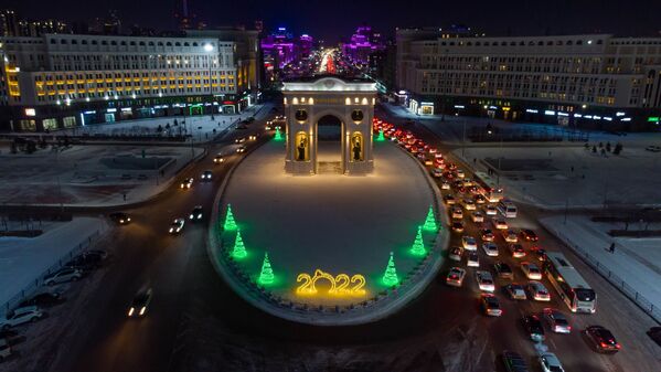 Так выглядит Триумфальная арка предпраздничным вечером с высоты птичьего полета. Даже столичные пробки по-своему добавляют новогоднего колорита.  - Sputnik Казахстан