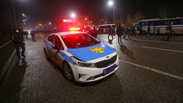 Люди проходят мимо полицейского автомобиля и автобусов к месту митинга в Алматы - Sputnik Қазақстан