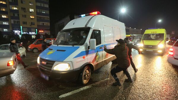 Люди нападают на полицейский микроавтобус во время акции протеста против повышения стоимости на топливо в Алматы - Sputnik Казахстан