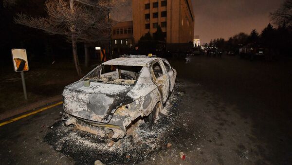 Сгоревшая машина возле мэрии во время акций протеста, вызванных повышением цен на топливо в Алматы, Казахстан - Sputnik Қазақстан